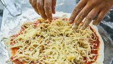 Una pizza casera puede propiciar buenos ratos en familia aprendiendo a cocinar.
