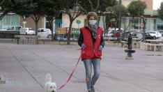 Una voluntaria de Cruz Roja de Huesca pasea el perro de una señora que no podía salir.