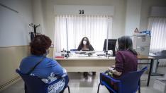 Dos mujeres, este viernes, son atendidas por una trabajadora social en el nuevo Centro de Atención a la Dependencia de Zaragoza.