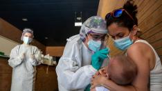 Una sanitaria realiza un test PCR a un niño en un espacio habilitado en un centro de salud de Zaragoza.,