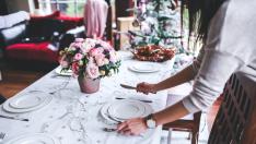 Una mujer preparando la mesa para comer en casa