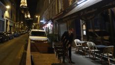 Un camarero retira las mesas de la terraza de un bar en París.