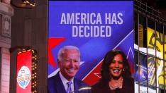 People celebrate as media announced that Democratic U.S. presidential nominee Joe Biden and vice presidential nominee Kamala Harris (seen on screen) have won the 2020 U.S. presidential election on Times Square in New York City