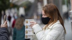 Una mujer con varios décimos de lotería en Sevilla.