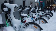 Bicicletas cubiertas de nieve tras la borrasca Filomena, en Madrid.