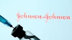 FILE PHOTO: Vial and syringe are seen in front of displayed Johnson&Johnson logo in this illustration