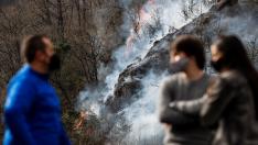 Varias personas observan este domingo en Endarlatsa (Guipúzcoa) un foco del incendio forestal.