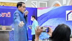El primer ministro tailandés rocía con gel hidroalcohólico a los periodistas.