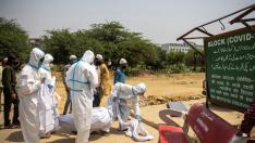 Trabajadores sanitarios retiran un cadáver de un enfermo de covid en India