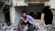 Una madre es besada por su hijo sobre las ruinas de su casa en Gaza.