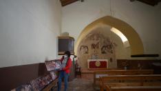 Sara Ros, en el interior de la ermita de Camañas, muestra reproducciones de la decoración de la techumbre.