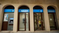 A woman leaves a Sabadell bank office in Barcelona