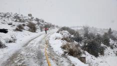 Un bombero, el domingo, lleva una manguera entre la nieve