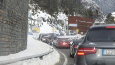 Tráfico denso por la nieve en Canfranc, el mediodía de este lunes.