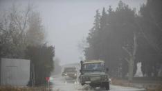 Dos vehículos militares, este lunes, en la carretera de acceso a Alfocea por Monzalbarba cortada por la crecida.