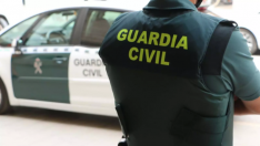 Un agente de la Guardia Civil junto a un vehículo oficial, en una imagen de archivo.