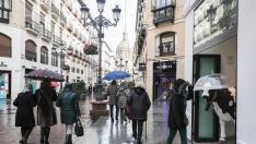 Lluvia en Zaragoza. Gente comprando en la calle Alfonso. Lluvias. gsc