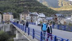 Turistas atravesando el puente sobre el río Ara de Broto.