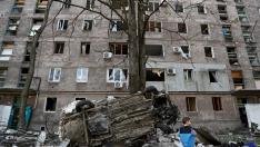 Un chico frente a un edificio derruido por los ataques rusos en Mariupol