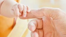 Un padre da la mano a su bebé.