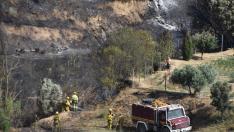 Equipos de extinción en la zona afectada por el incendio de Barbastro este domingo por la mañana.
