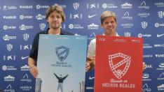 Josete Ortas y Agustín Pueyo sostienen los carteles de la campaña de abonados de la SD Huesca para la temporada 2022-23.