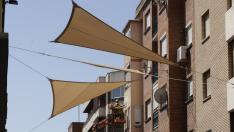La comercial calle de Delicias en Zaragoza comienza a lucir este lunes una imagen más moderna y fresca gracias a la colocación de 50 toldos triangulares a lo largo de toda la vía color arena.