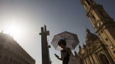 Una mujer se protege del sol con un paraguas ayer tarde en la plaza del Pilar de Zaragoza