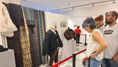 Los visitantes observan los detalles de las prendas expuestas en 'El vestir de la Litera'.