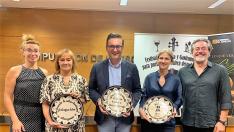 Representantes de En Clave de Aragón y el diputado Roque Vicente (en medio) muestran los galardones del certamen.