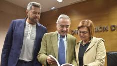 Alberto Sabio, Ángel Garcés y Maribel de Pablo ojean el libro ‘Huesca de cine’.