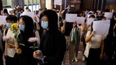 Los manifestantes sujetan folios blancos en protesta por las restricciones por la covid.