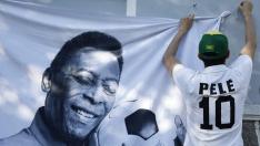 Un fan colocando un póster en honor de Pelé en Santos, Brasil.