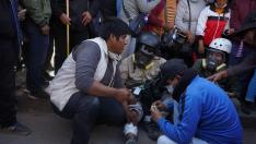 Varios hombres ayudan al fotógrafo de la Agencia EFE Aldair Mejía