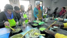Las usuarias de Gambaru preparan la carbonara de champiñones y ajos para la pasta vegetal, en la cocina del Joaquín Roncal.