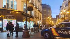 Un coche de la Policía Nacional, en la puerta de la joyería Regia de Zaragoza, donde ha tenido lugar el robo.