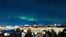 Varias personas contemplan las luces nocturnas de las autoras borales en Estocolmo (Suecia).