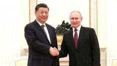 Vladimir Putin y Xi Jinping se saludan momentos antes de la reunión privada que han mantenido este lunes en Moscú.