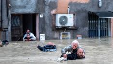 Dos carabinieri tratan de salvar a afectados por las inundaciones en la región de Emilia-Romaña, en Italia.