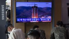 Varias personas, en Seúl delante de una televisión que informa del supuesto lanzamiento de un cohete espía de Corea del Norte.