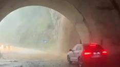 Un conductor detenido en un túnel mientras la tromba de agua cae en la entrada como una cascada.