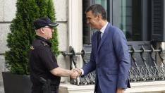 El presidente del Gobierno en funciones Pedro Sánchez, saluda a un agente de policía a su llegada este jueves al Congreso