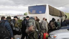 Varios hombres suben a un autobús en una oficina de reclutamiento durante la movilización militar parcial de Rusia