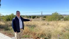 El alcalde de Castejón del Puente, Antonio Comps, junto al terreno donde se va a edificar.