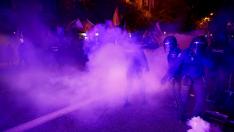 La policía antidisturbios española lanza gases lacrimógenos durante una protesta cerca de la sede del Partido Socialista de España (PSOE)