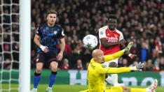 El portero del Sevilla, Marko Dmitrovic, mira el balón mientras Bukayo Saka del Arsenal anota el segundo gol de su equipo durante el partido de fútbol del Grupo B de la Liga de Campeones entre Arsenal y Sevilla