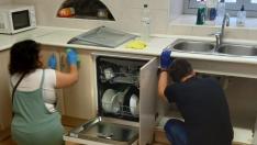 Dos personas realizan labores de limpieza en los cursos impartidos por Cáritas.