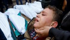 Un niño herido por los bombardeos israelíe sloora desoconsolado ante lcadáveres de sus familiares en el hospital de Jan Yunis en Gaza