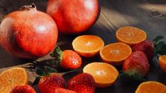 Frutas: granada, naranjas y fresas.