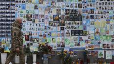 Un soldado pasa por una  pared con las fotos de militares caídos en la guerra con Rusia.